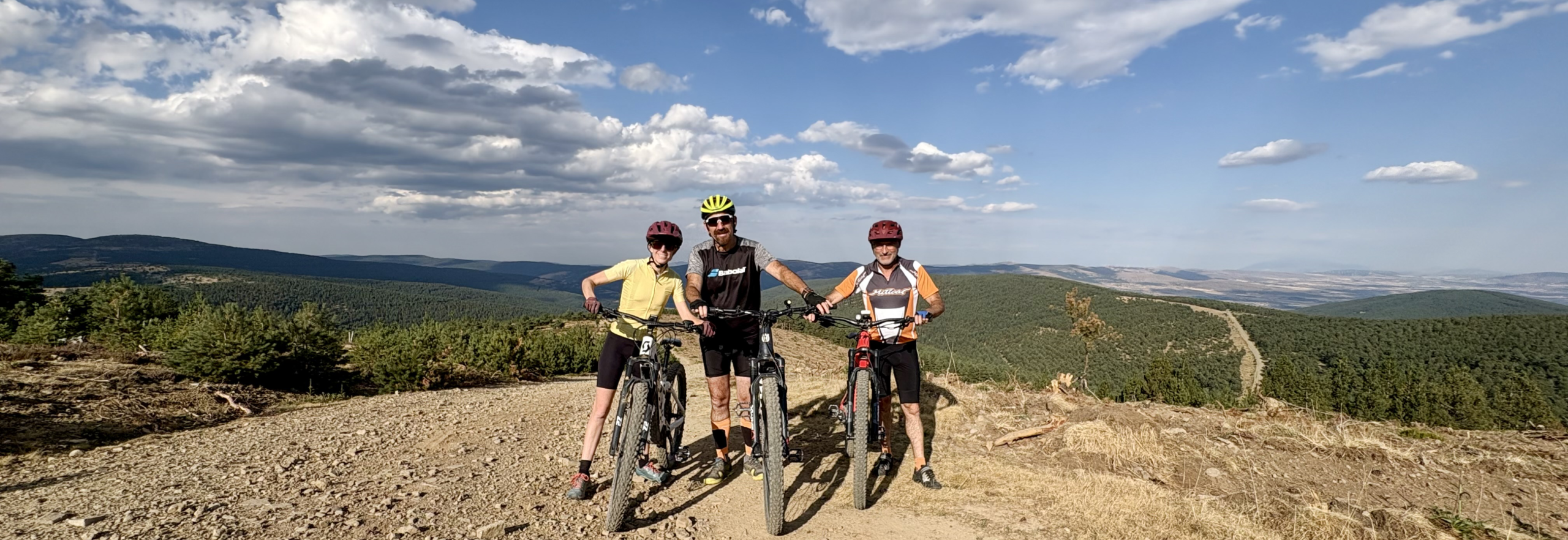 Tres ciclistas en una pista de tierra con vistas a los pinares de Soria
